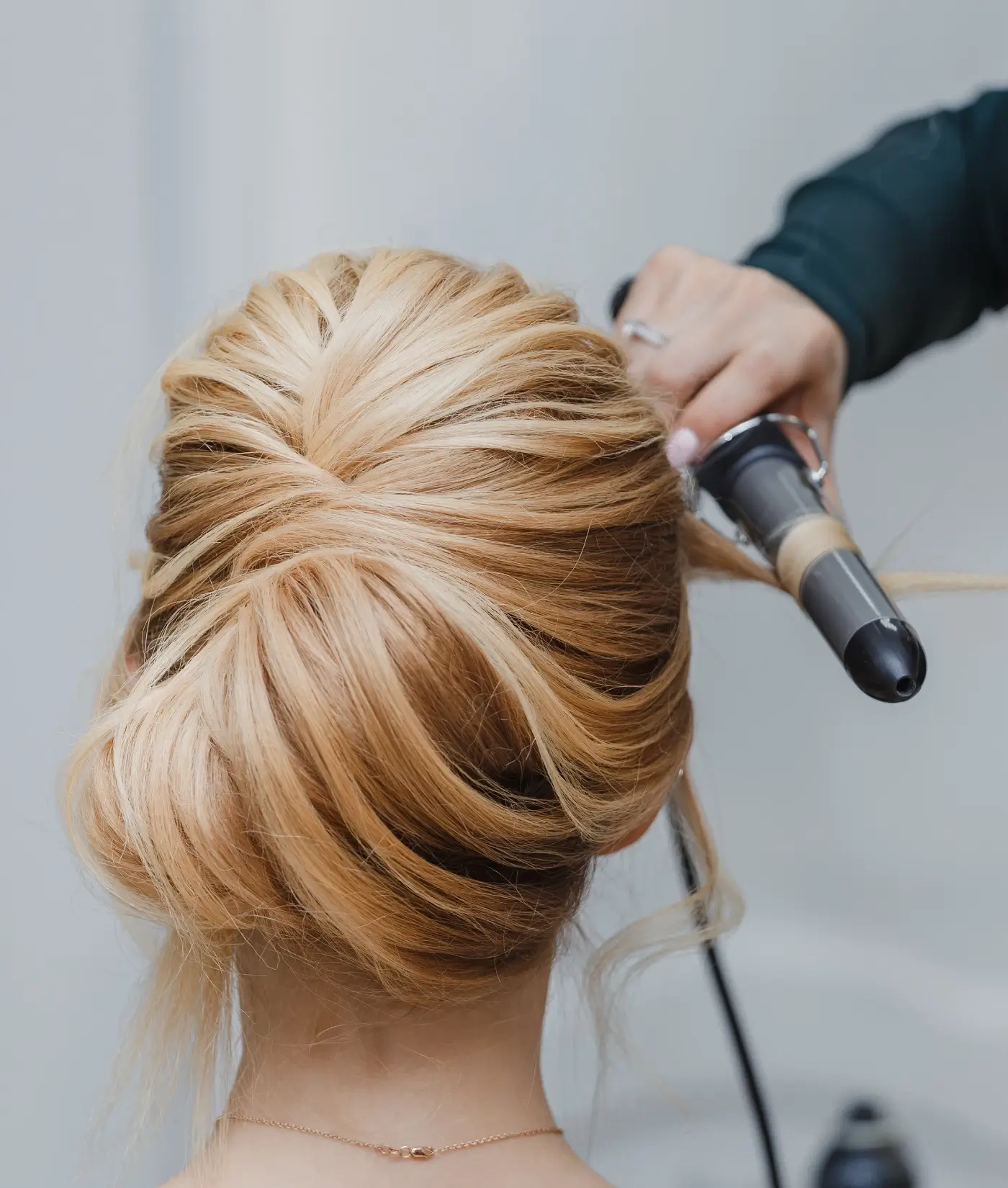 A woman getting her hair done with a blow dryer. A woman getting her hair done with a blow dryer.