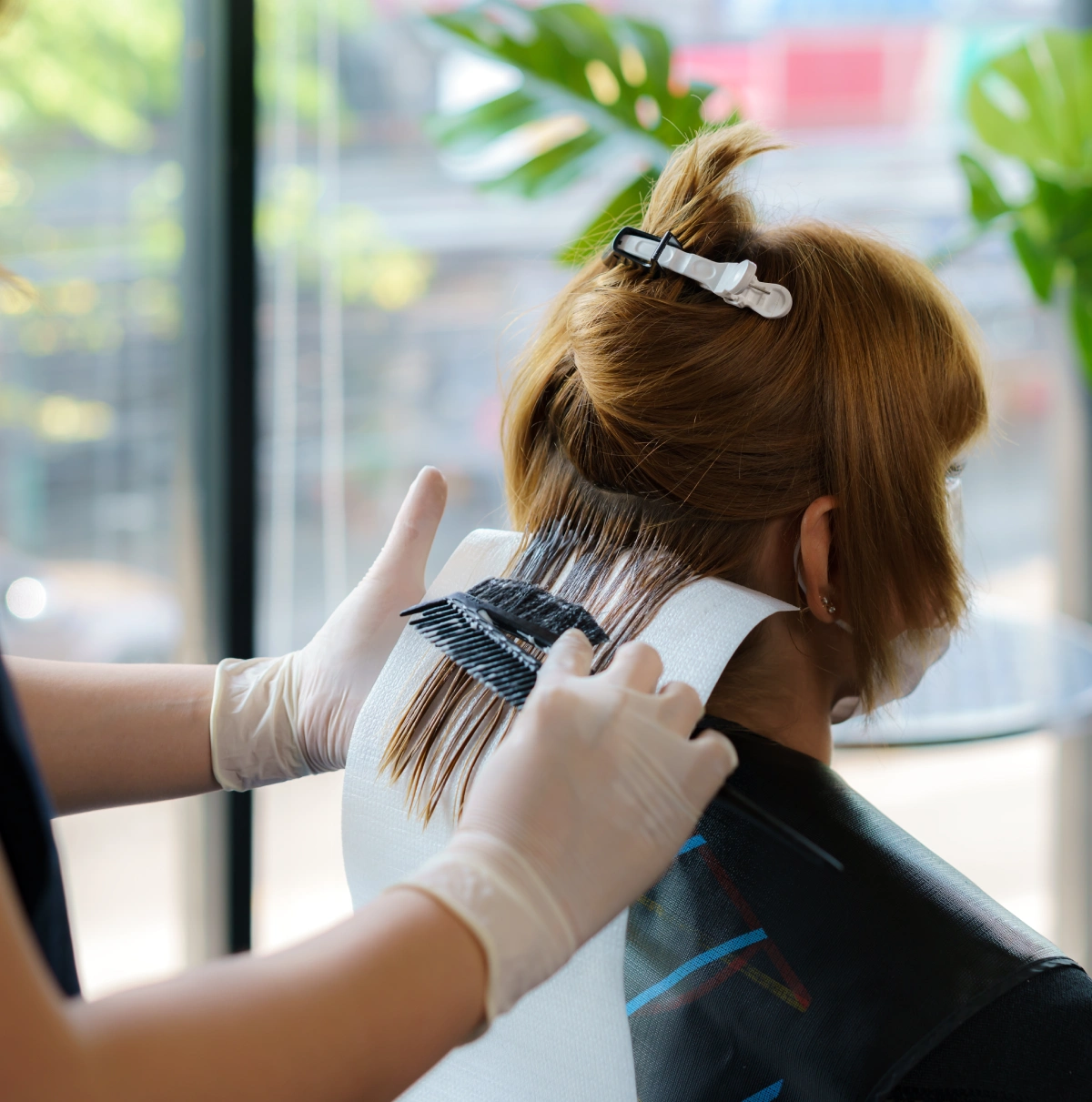A woman getting her hair cut by a stylist. A woman getting her hair cut by a stylist.