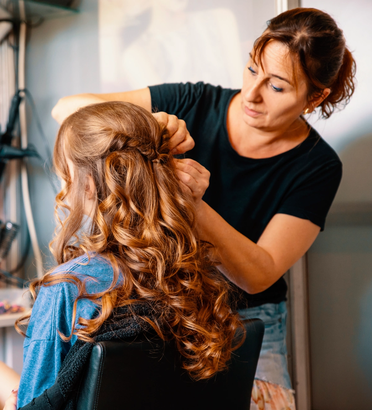 A woman is fixing another person 's hair