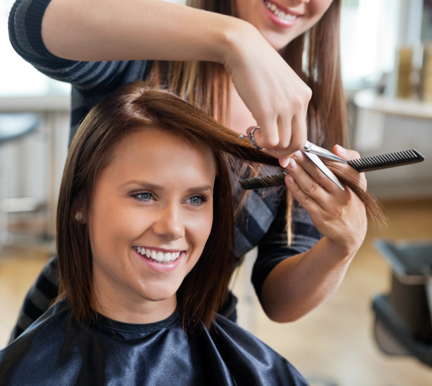 A woman getting her hair cut by another person A woman getting her hair cut by another person