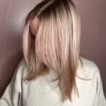 Blonde hair with subtle pink highlights.