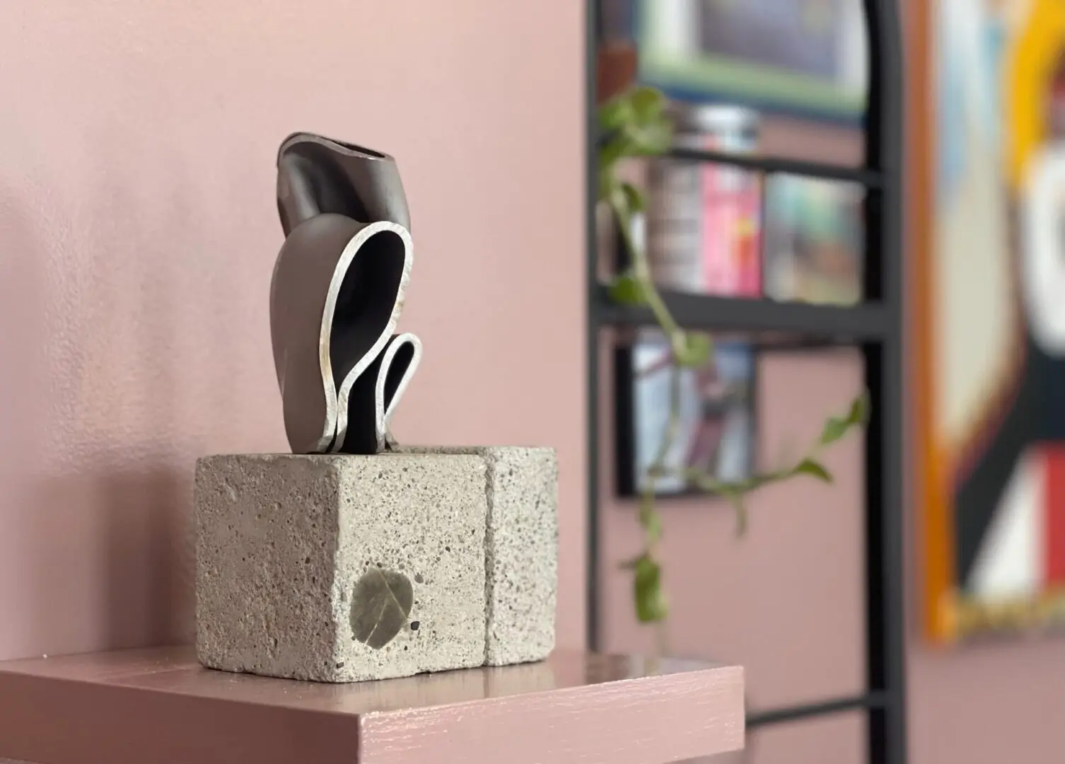 Modern sculpture on a concrete block display.