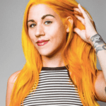 Person with bright orange hair, striped shirt.