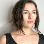 Woman with short brown hair, neutral expression.