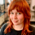 Person with red hair and nose ring.