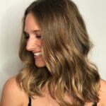 Woman with wavy, shoulder-length hair smiling.